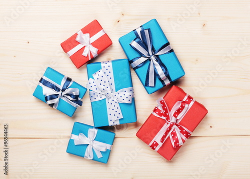 wrapped gift boxes with ribbon bows on wooden board