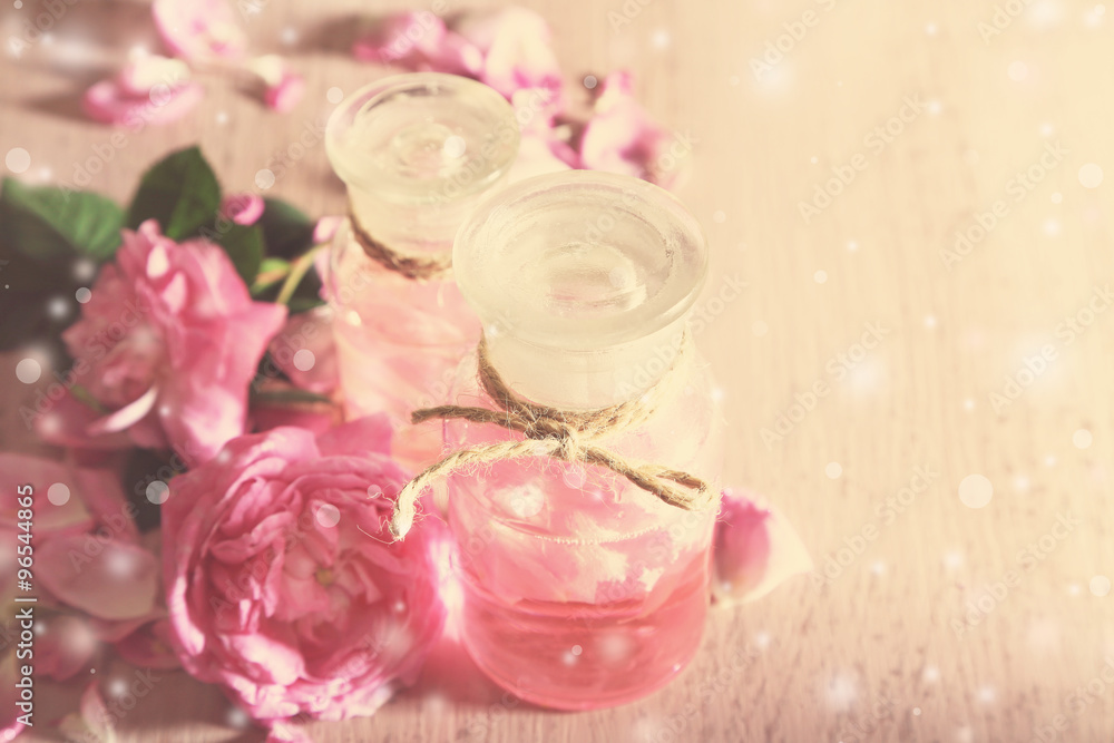 Rose oil in bottles on light background Rose oil in bottles on light background