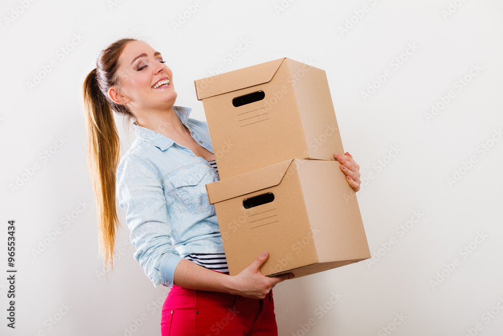 Woman moving into apartment house carrying boxes. Woman moving into apartment house carrying boxes.