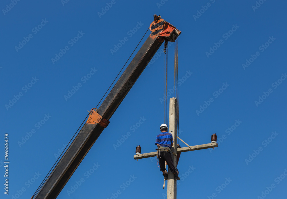 electrician install wire of the power line on electric power pole with crane. electrician install wire of the power line on electric power pole with crane.