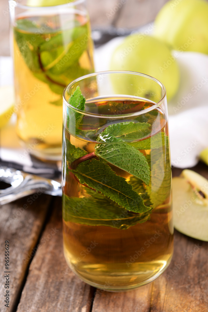 Glass of apple juice with fruits and fresh mint on table close up Glass of apple juice with fruits and fresh mint on table close up