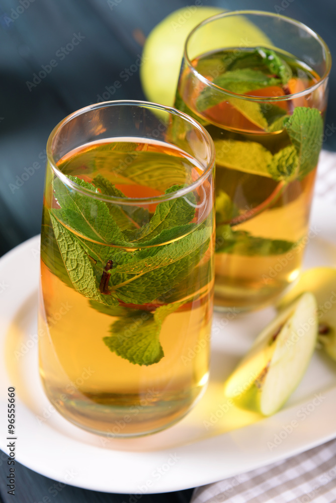 Glasses of apple juice with fruits and fresh mint on table close up Glasses of apple juice with fruits and fresh mint on table close up