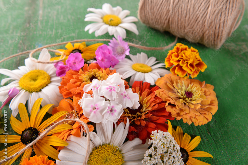 Obraz premium Fresh colorful flowers on wooden table, closeup