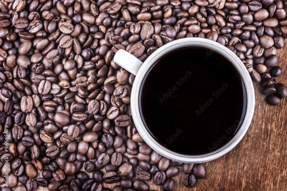 Coffee cup and coffee beans on table top view Coffee cup and coffee beans on table top view