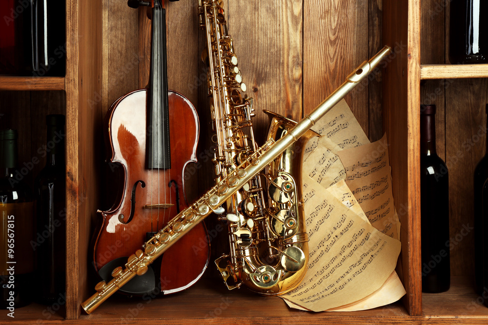 Musical instruments: saxophone, violin and flute with notes on wooden  background Stock Photo | Adobe Stock