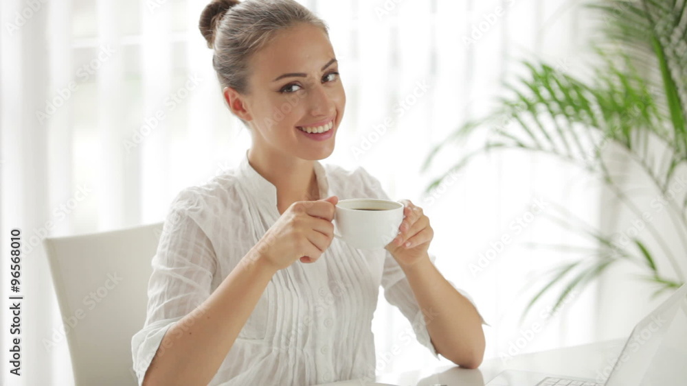 Beautiful businesswoman sitting at table with cup of coffee Beautiful businesswoman sitting at table with cup of coffee