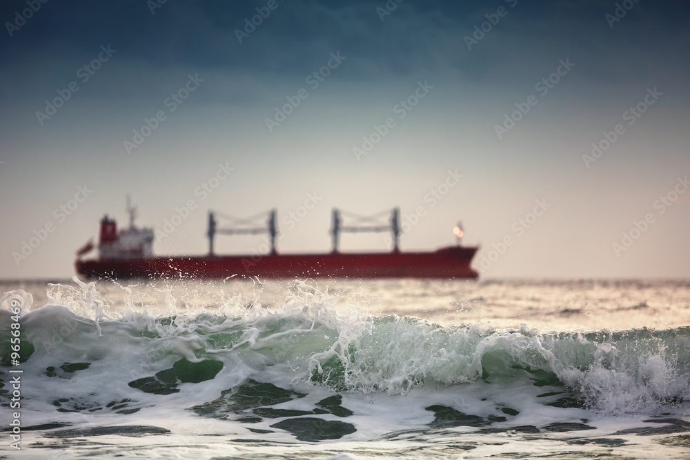 Sun setting at the sea with sailing cargo ship Sun setting at the sea with sailing cargo ship