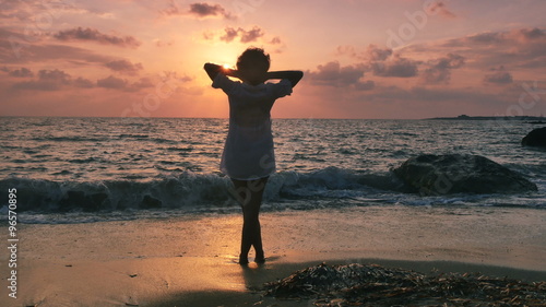 a woman enjoying a holiday by the sea at sunset 