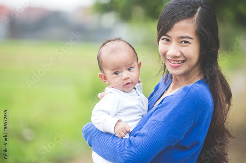 Beautiful Asian mother holding her baby daughter