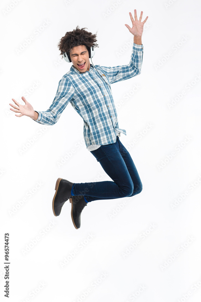 Cheerful afro american man in headphones jumping Cheerful afro american man in headphones jumping