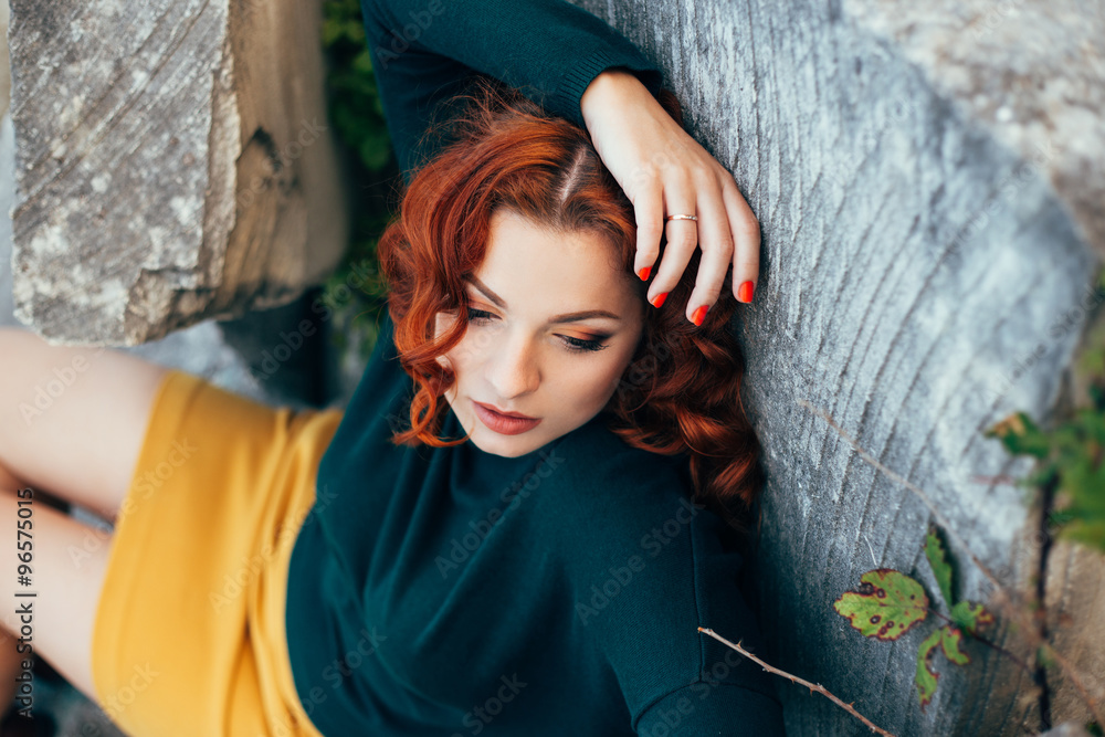 Beautiful young woman with bright red hair posing outdoors Beautiful young woman with bright red hair posing outdoors