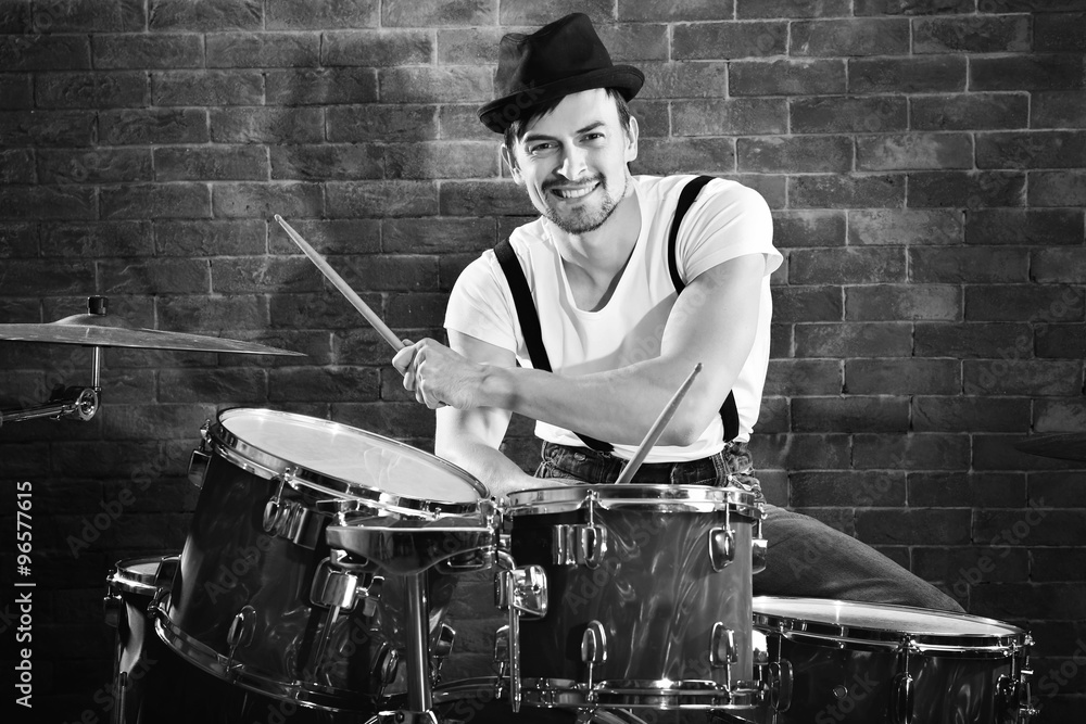 Musician playing the drums on brick wall background Musician playing the drums on brick wall background