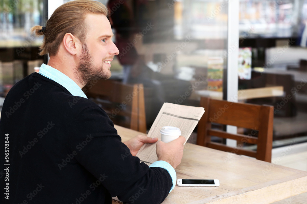 Young attractive businessman having lunch and working in a cafe Young attractive businessman having lunch and working in a cafe