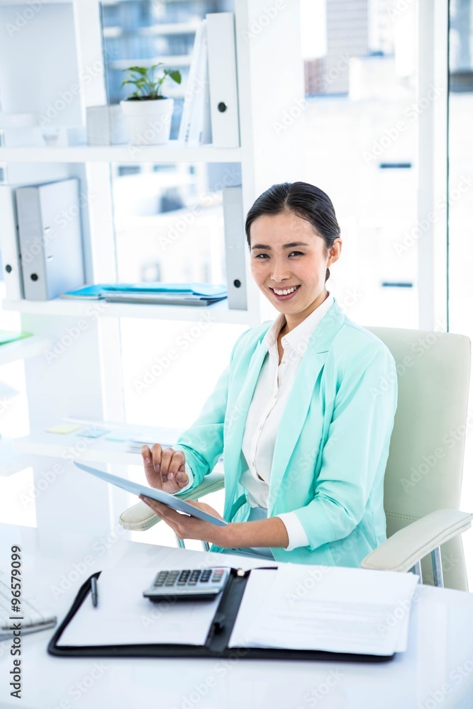 Smiling businesswoman with notes at desk Smiling businesswoman with notes at desk