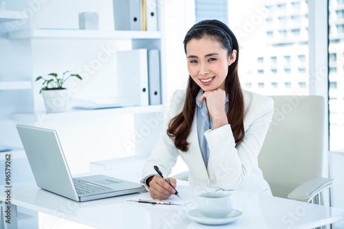 Wallpaper Mural Smiling businesswoman writing on clipboard Torontodigital.ca