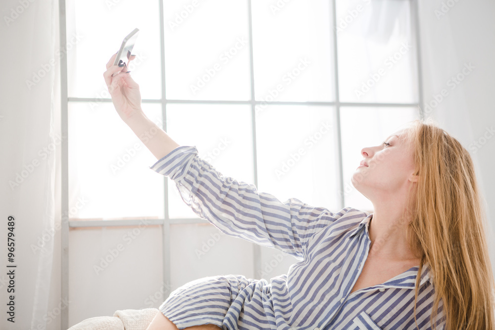 Lovely woman lying and taking photo of herself using cellphone Lovely woman lying and taking photo of herself using cellphone
