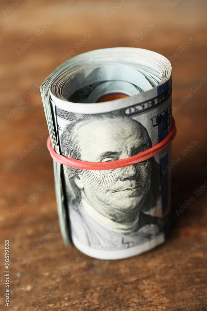 Dollars roll on wooden background Dollars roll on wooden background