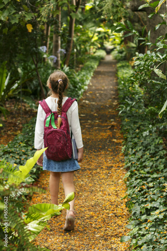 Little girl is walking on the botanic park.