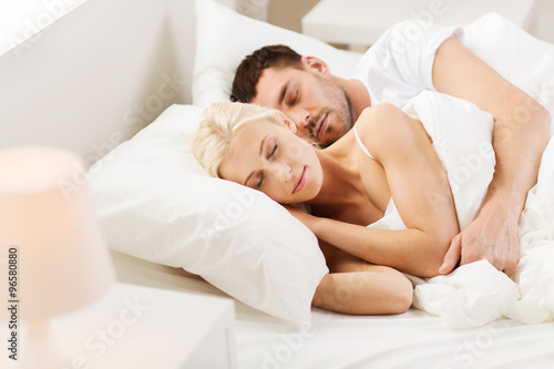 happy couple sleeping in bed at home