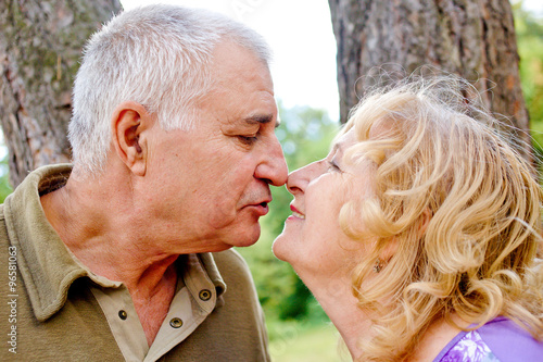 Two happy seniors kissing and having fun