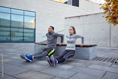 Tableau sur toile couple doing triceps dip exercise outdoors