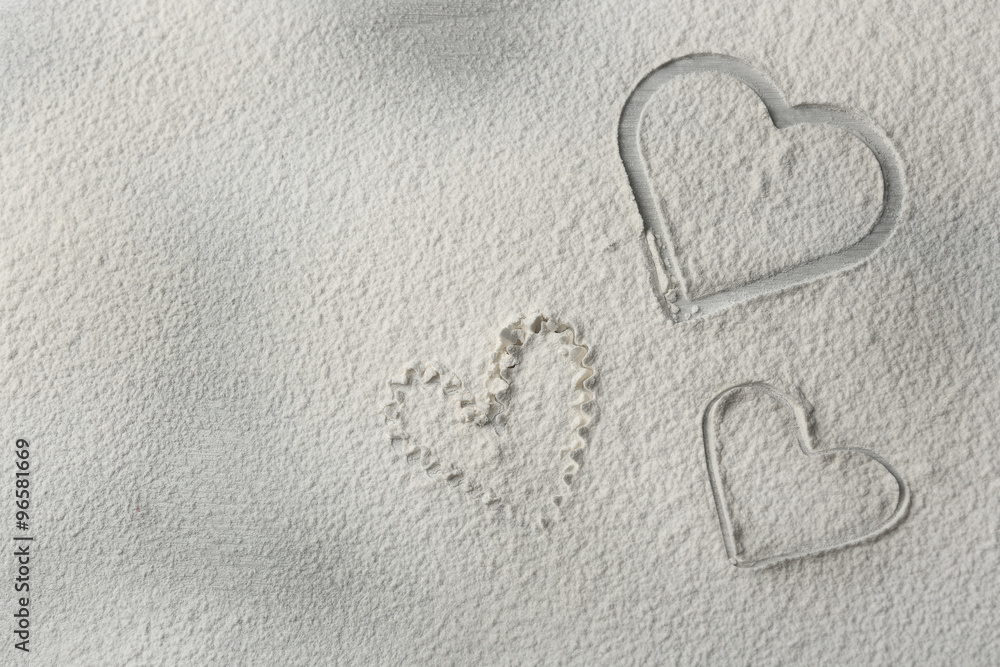Hearts of flour on wooden background