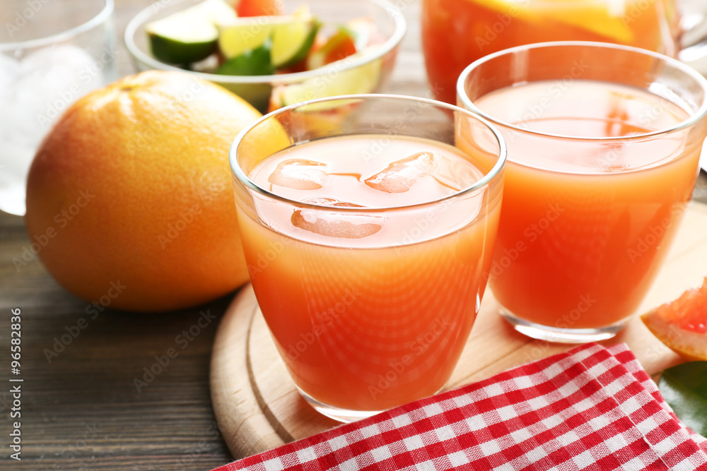 Citrus juice with ice and fresh fruits on cutting board Citrus juice with ice and fresh fruits on cutting board