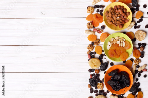 Dried fruits and nuts on white wooden background