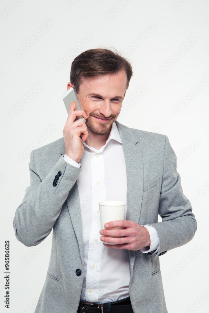 Businessman holding cup with coffee and talking on the phone Businessman holding cup with coffee and talking on the phone
