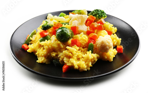 Rice with vegetables on black plate isolated on white