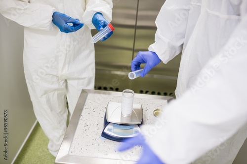 Mid section of scientists working with hazardous chemical in laboratory