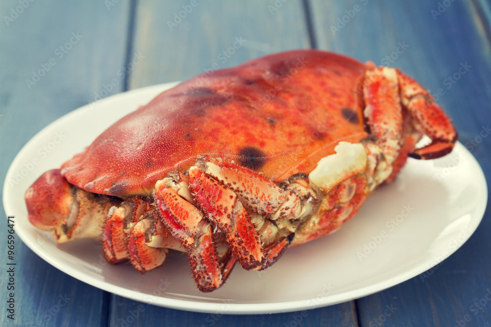 boiled crab on white plate on blue wooden background boiled crab on white plate on blue wooden background
