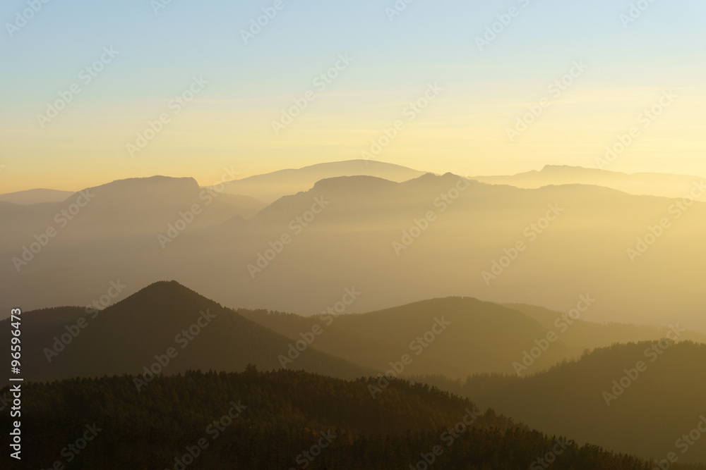 mountain silhouettes at sunset with haze