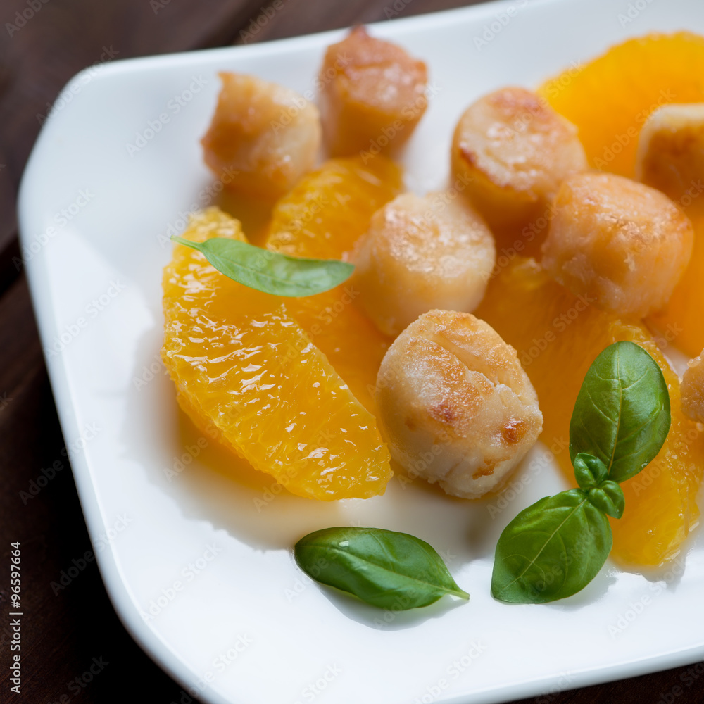 Close-up of fried sea scallops served with orange fillet Close-up of fried sea scallops served with orange fillet
