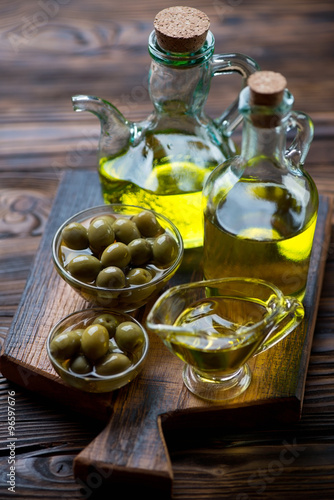 Still life with extra virgin olive oil and green olives, closeup