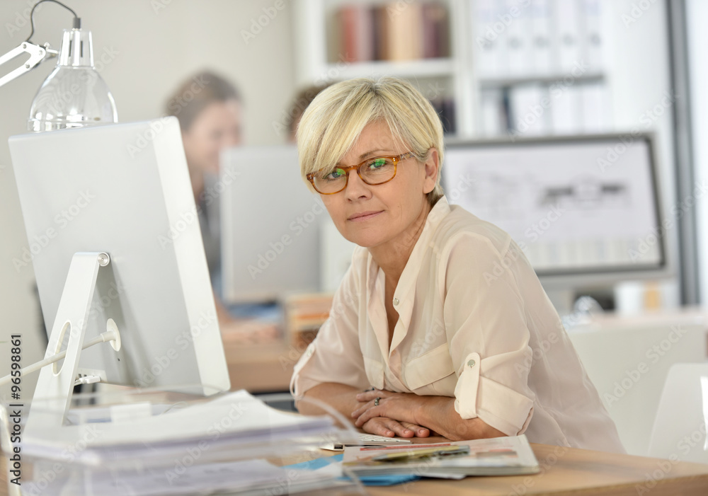 Smiling senior businesswoman working in office Smiling senior businesswoman working in office