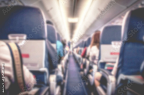 blurry image of interior of airplane with passengers on seats