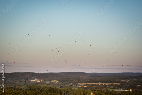 Landscape with many hot air balloons in the sky
