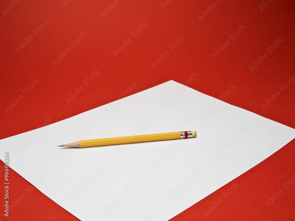 yellow pencil on white paper with red background yellow pencil on white paper with red background