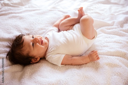 Smiling newborn on the bed photo