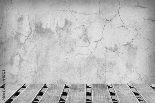 Room with a concrete wall and wooden floors.