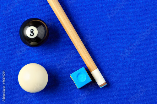 Billiard balls, cue and chalk in a blue pool table. photo