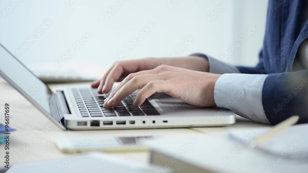 Businesswoman working at office desk and typing on a laptop, hands close up Businesswoman working at office desk and typing on a laptop, hands close up