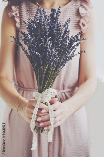 Fototapeta Naklejka Na Ścianę i Meble -  Woman in vintage dress holding bunch of lavender in her hands