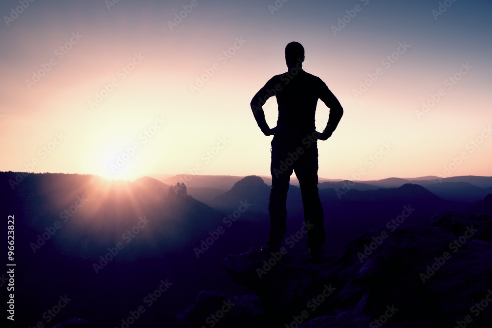 Red daybreak. Slim tourist on peak in rock empires park is watching over the misty and foggy landscape to Sun Red daybreak. Slim tourist on peak in rock empires park is watching over the misty and foggy landscape to Sun