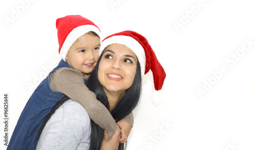 christmas, family, childhood and people concept - happy mother and little girl in santa hats over holidays isolated on white