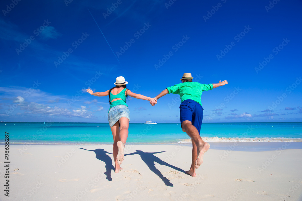 Young happy couple on white beach at summer vacation Young happy couple on white beach at summer vacation