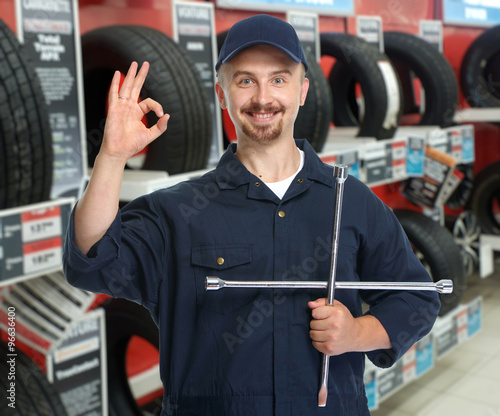 Car mechanic with tire wrench.