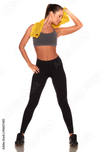 Pretty fitness woman in sport style standing against isolated white background