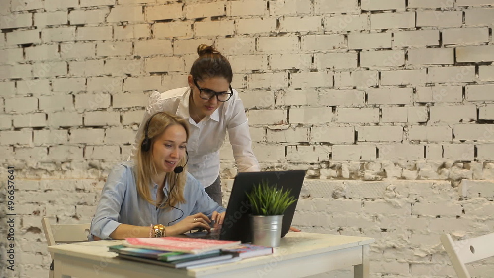 Two young businesswomen having a meeting in the office sitting